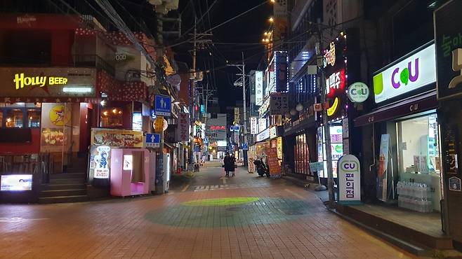 인적 드물어진 신촌 (서울=연합뉴스) 정성조 기자 = 사회적 거리두기가 2단계로 올라가면서 음식점 등 정상 영업이 오후 9시까지만 가능해진 24일 밤 서울 서대문구 신촌 거리가 한산하다. 2020.11.24 xing@yna.co.kr