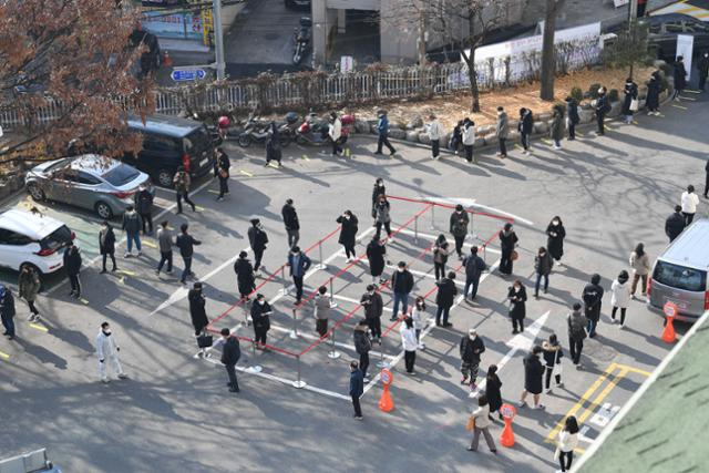 최근 노량진 학원 집단감염으로 확진자가 급증하고 있는 가운데 26일 오후 서울 동작구청에 마련된 선별진료소에서 검사 대기자들이 줄을 서 있다.배우한 기자