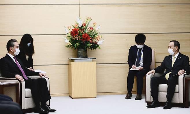 스가 요시히데(오른쪽) 일본 총리가 25일 방일 중인 왕이(왼쪽) 중국 외교담당 국무위원 겸 외교부장을 도쿄 총리관저에서 접견하고 있다. 도쿄 AFP=연합뉴스