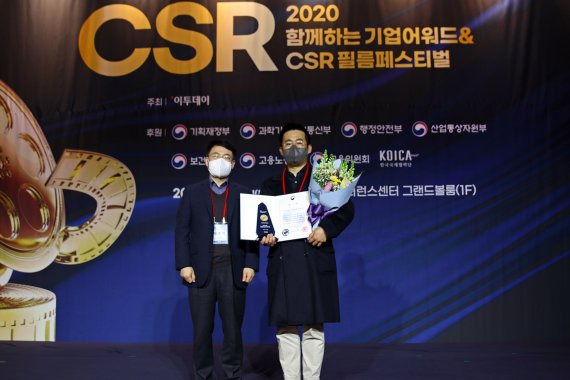 오현동공(오른쪽) 롯데칠성음료 CSR담당 매니저가 2020 CSR 필름 페스티벌 보건복지부장관상 수상한 후 이호영 연세대 CSR 연구센터장과 기념촬영을 하고 있다. (사진=롯데칠성)