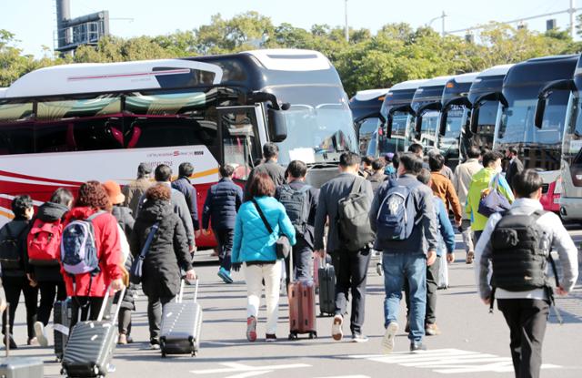 지난 25일 오전 제주국제공항에서 단체 관광객들이 전세버스 승차장으로 향하고 있다. 뉴스1