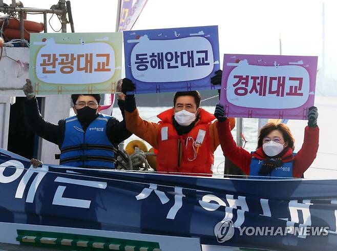 동해안대교 건설에 힘 모은 포항 정치권 (포항=연합뉴스) 손대성 기자 = 28일 경북 포항 앞바다에서 국민의힘 김병욱 의원(포항 남구·울릉. 왼쪽부터), 이강덕 포항시장, 김정재 의원(포항 북구)이 배에 올라 동해안대교 건설을 촉구하는 피켓을 들어 보이고 있다.   2020.11.28 sds123@yna.co.kr
