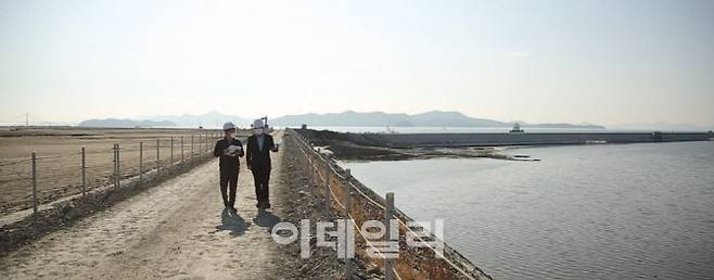 이데일리 취재진이 이형하 부산항만공사 스마트항만실장 설명을 들으며 진해신항(부산항 제2신항) 공사 현장을 걸어가고 있다. 왼쪽은 준설토로 바다를 매립한 것이고 오른쪽은 매립 작업이 진행 중인 곳이다. 이데일리 DB