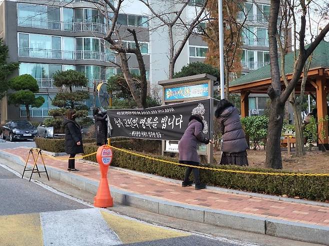 경기 군포시 산본동의 백두한양아파트 주민들이 불이 난 화재 현장 앞에 고인의 명복을 비는 추모 플래카드를 내걸고 있다. 오상도 기자