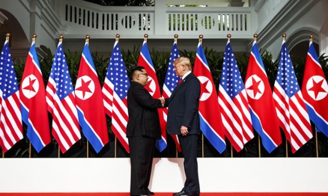2018년 싱가포르에서 열린 북미정상회담에서 양국 국기를 배경으로 악수를 하는 두 정상. 백악관 홈페이지