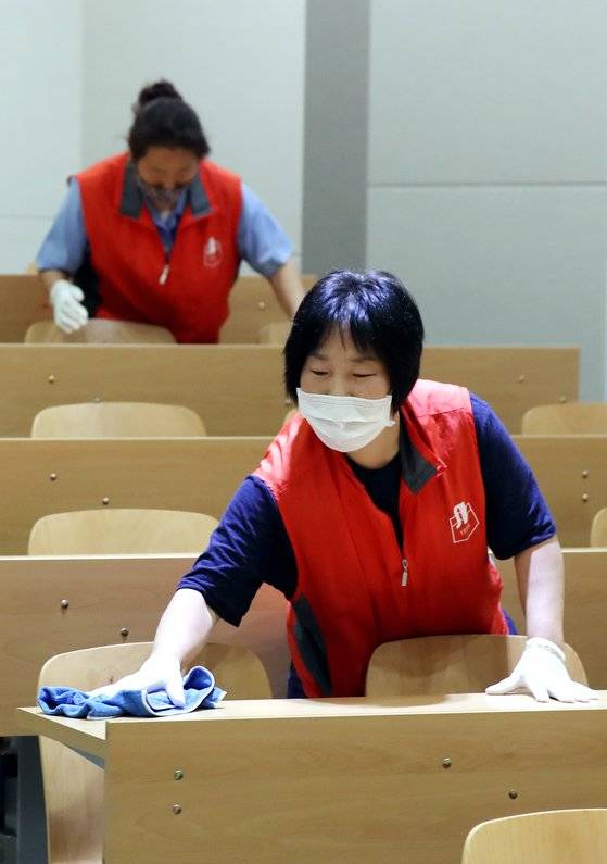 지난 6월 인천시 미추홀구 인하대학교에서 방역업체 관계자들이 강의실 책상을 닦고 있다. 연합뉴스