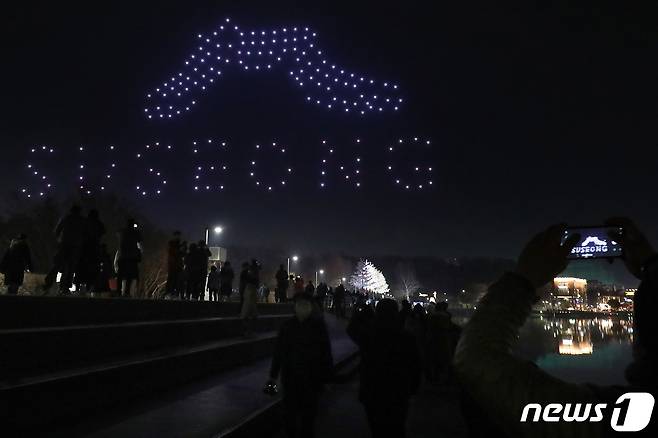 11일 오후 대구 수성구 두산동 수성못에서 열린 '제2회 수성빛예술제'를 찾은 시민들이 200대의 드론이 전하는 희망 메시지를 감상하고 있다. 2020.12.11/뉴스1 © News1 공정식 기자