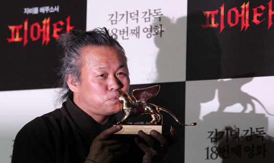 Filmmaker Kim Ki-duk poses for the camera with his Golden Lion trophy at the press event in central Seoul on Sept. 11, 2012, after he received the prize in Venice for his 2012 film ″Pieta." [JOONGANG ILBO]