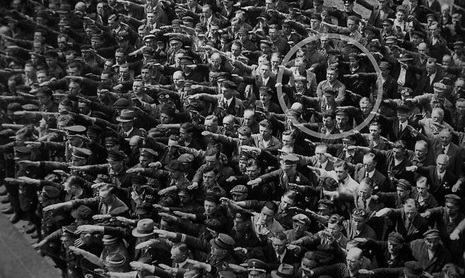 1936년 함부르크의 한 조선소에서 벌어진 독일 해군 훈련함 진수식. 사진 속에서 단 한 사람, 아우구스트 란트메서(원 안)만이 나치 경례를 거부한 채 팔짱을 끼고 있다.