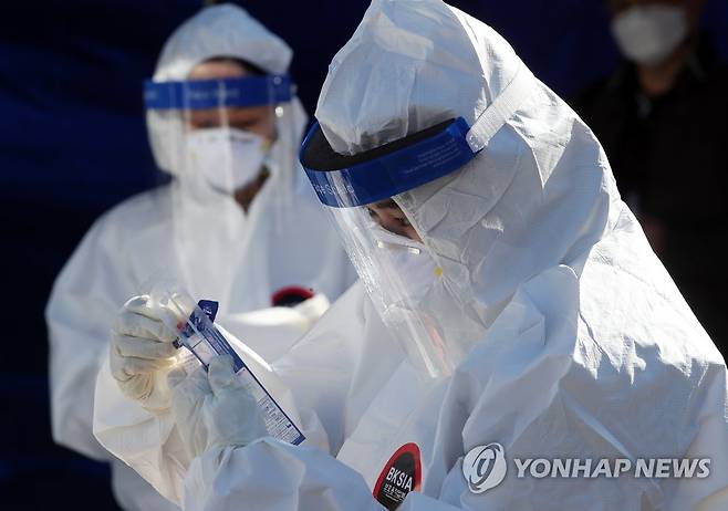 추위와 사투 벌이는 의료진 (서울=연합뉴스) 임헌정 기자 = 14일 서울역 광장에 마련된 신종 코로나바이러스 감염증(코로나19) 임시 선별검사소에서 의료진의 얼굴 가리개(페이스 실드)에 입김으로 인한 성에가 끼어 있다. 2020.12.14 kane@yna.co.kr