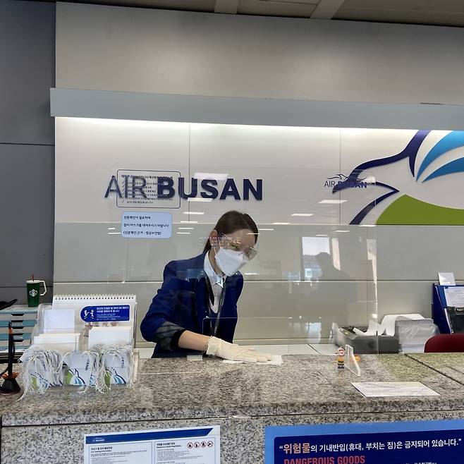 An Air Busan staff member cleans an airport check-in counter. (Air Busan)