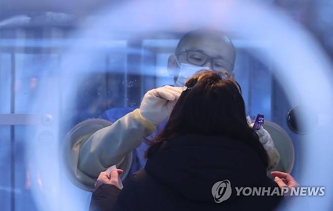 검체 채취하는 의료진 (서울=연합뉴스) 홍해인 기자 = 21일 서울 중구 시청 앞 서울광장에 마련된 신종 코로나바이러스 감염증(코로나19) 중구 임시 선별검사소에서 의료진이 검체를 채취하고 있다. 2020.12.21 hihong@yna.co.kr
