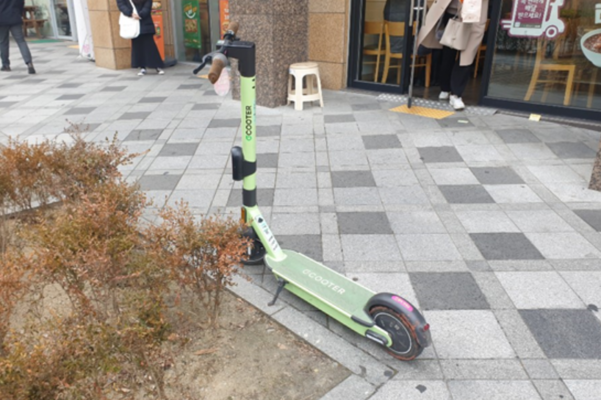 지난 23일 세종시 길가에 방치된 전동킥보드. 전용주차장이 설치되어있지만 전동킥보드는 원동기가 아니라 다른 곳에 주차해도 직접 제재할 수 있는 근거가 없다./최효정 기자