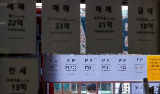 한 시민이 부동산 매물 시세가 게재된 부동산공인중개업소 매물정보 게시판 앞을 지나가고 있디. 



연합뉴스