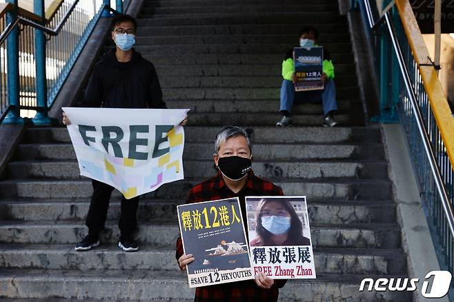 홍콩 중국 연락사무소 앞에서 장잔 등의 석방을 요구하며 시위하는 민주화 운동가들. © 로이터=뉴스1