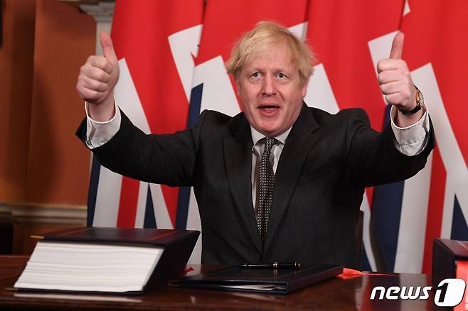 보리스 존슨 영국 총리가 30일(현지시간) 런던 다우닝가 10번지 총리관저에서 영국과 EU의 47년 동거를 끝내는 브렉시트 무역 합의문에 서명을 한 뒤 두 손 엄지를 치켜세우고 있다. © AFP=뉴스1 © News1 우동명 기자