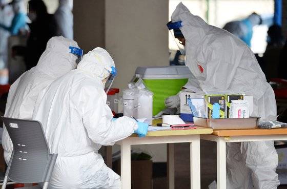 신종 코로나바이러스 감염증(코로나19) 신규 확진자가 1050명 늘어 초비상이 걸린 30일 오후 대전의 한 중학교에 마련된 코로나19 임시 선별진료소에서 의료진들이 학생들을 검사하고 있다. [프리랜서 김성태]