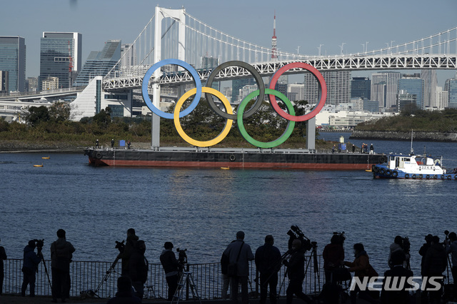 [도쿄=AP/뉴시스] 지난 1일 일본 도쿄 오다이바 해상공원에 올림픽 상징인 오륜 조형물을 사람들이 구경하고 있다. 지난 8월 철거됐던 조형물은 4개월 만에 다시 설치됐다. 2020.12.02.
