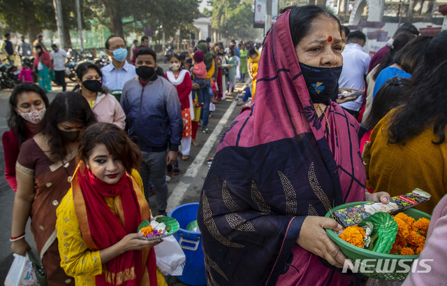 1일(현지시간) 인도 가우하티의 한 힌두 사원 앞에 새해 방문객들이 마스크를 쓰고 줄 서 있다. 2021.01.01.