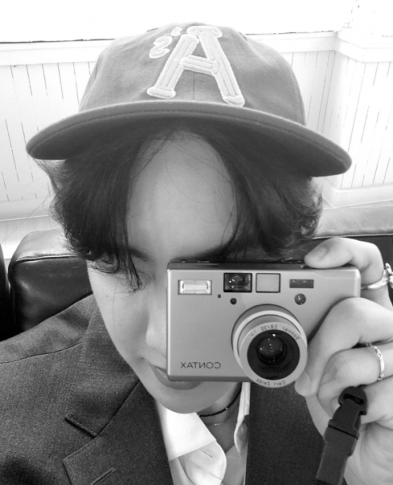 Another photo featured J-Hope sitting in a white suit in the atmosphere, taking a mirror selfie, and J-Hope posing as if he were taking a picture with his face on Camera.