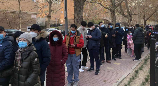 중국 수도 베이징과 동북부 랴오닝성에서 코로나19 확진자가 속출하고 있다. 사진은 지난달 26일 베이징 차오양구 왕징의 한 아파트 안에서 핵산검사를 받으려고 줄지어 서 있는 주민들.<사진=연합뉴스>