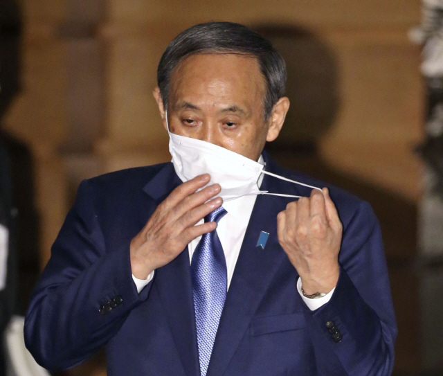 스가 요시히데(菅義偉) 일본 총리가 지난달 16일 오후 일본 총리관저에서 기자들의 취재에 응하며 마스크를 벗고 있다. 그는 코로나19 확산세가 거센 가운데 자신이 다수가 참석하는 회식에 참석한 것에 대해 사과했다./교도연합뉴스