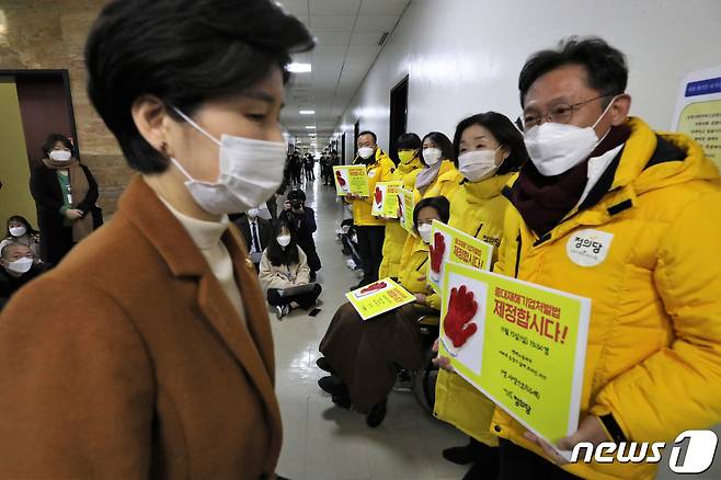 강은미 원내대표를 비롯한 정의당 의원들이 5일 오후 서울 여의도 국회 법제사법위원회 법안심사제1소위원회 회의실 앞에서 중대재해기업처벌법 제정을 촉구하며 피켓 시위를 하는 가운데 백혜련 소위원장이 회의에 참석하고 있다. 2021.1.5/뉴스1 © News1 신웅수 기자