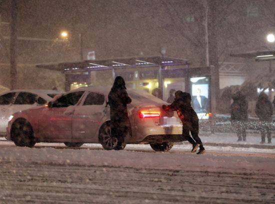 서울 전역에 대설주의보가 발효된 6일 오후 서울 삼성역 인근 도로에서 시민들이 차를 밀고 있다. [이미지출처=연합뉴스]