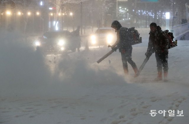 6일 서울을 비롯한 중부지방 퇴근길에 눈이 내렸다. 청계광장에서 관계자들이 눈을 치우고있다. 김재명 기자 base@donga.com