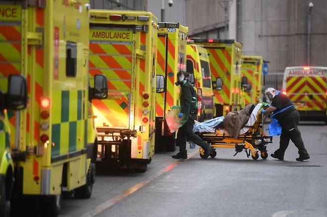 영국 런던의 로열 런던 병원에서 5일(현지 시간) 의료 요원들이 구급차로 이송한 환자를 옮기고 있다. 영국 정부는 이날 0시부터 잉글랜드 전역을 대상으로 3차 봉쇄조치에 들어갔다. 연합뉴스 제공