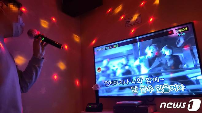 정부가 사회적 거리두기를 1단계로 하향 시행한 12일 저녁 경기 수원시 인계동의 한 코인노래방 손님이 마스크를 쓴 채 노래를 부르고 있다. © News1 최대호 기자