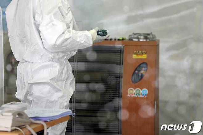 대설특보가 내려지는 등 한파가 기승을 부리는 7일 오전 광주시청 광장에 설치된 코로나19 임시 선별검사소에서 방역원들이 운영 준비를 마친 뒤 몸을 녹이고 있다. 2020.1.7/뉴스1 © News1 황희규 기자