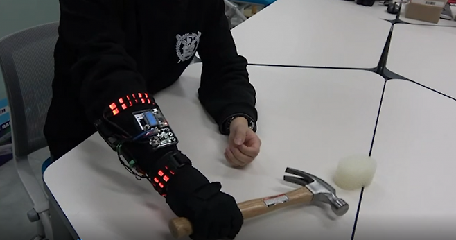 센서 하나로 악력을 키우는 로봇 장갑. 로봇 장갑을 끼고 망치를 잡자 불이 들어와 힘이 증강됐음을 알 수 있다. 서울대 제공