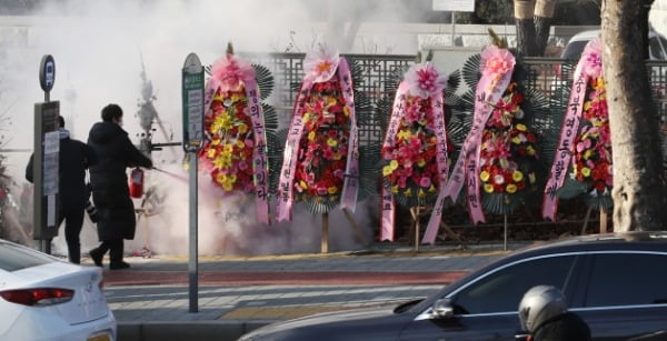 지난 5일 서울 서초구 대검찰청 관계자들이 응원화환들에 붙은 불을 끄고 있다.  뉴스1