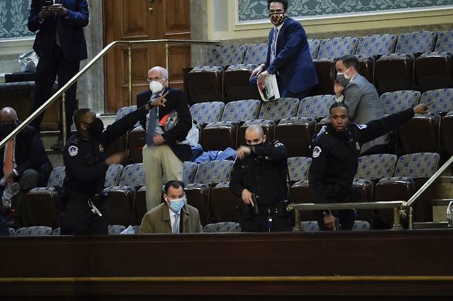 트럼프 지지자들이 6일(현지시간) 미국 워싱턴 연방의회 의사당에 난입해 점거하자 의원들이 대피하고 있다. 워싱턴|AP연합뉴스