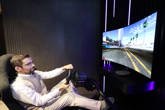 A model enjoys a game with LG Electronics' new 48-inch bendable OLED. [LG Electronics]