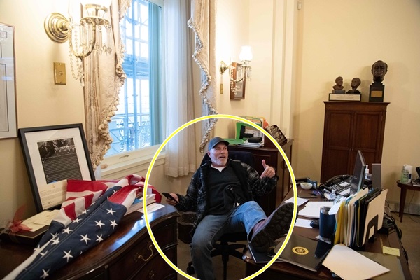 미국 국회의사당에 난입한 도널드 트럼프 대통령 지지자가 6일(현지시간) 낸시 펠로시 하원의장 사무실에서 의자에 앉아 발을 책상 위에 올리고 있다. AFP 연합뉴스