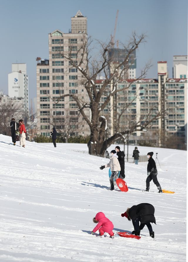 7일 오전 눈이 덮인 서울 송파구 올림픽공원을 찾은 시민들이 눈썰매를 즐기고 있다. 연합