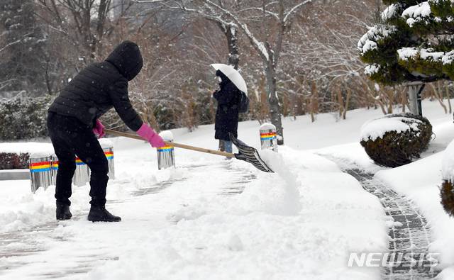 [광주=뉴시스] 류형근 기자 = 광주와 전남지역에 대설특보가 내려진 7일 오전 광주 동구 조선대학교 교정에서 학생들이 등교하는 가운데 교직원이 눈을 치우고 있다. 2021.01.07.hgryu77@newsis.com