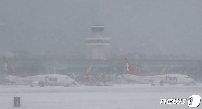 8일 오전 급변풍·강풍·대설특보가 발효 중인 제주국제공항 계류장에 항공기들이 멈춰서있다. 제주지방기상청에 따르면 이날 오전 7시30분 현재 제주도 산지에는 한파경보, 제주도 산지·동부·북부에는 대설경보, 제주도 서부·남부·추자도에는 대설주의보가 발효 중이다.2021.1.8/뉴스1 © News1 오현지 기자