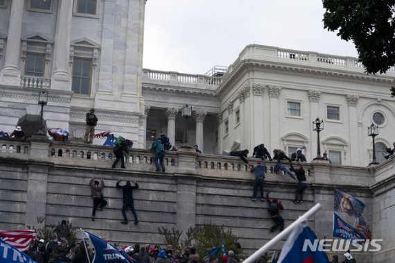 [워싱턴DC/AP=뉴시스]도널드 트럼프 미국 대통령 지지자들이 6일 미 워싱턴DC 국회의사당에 난입하기 위해 의사당 벽을 기어오르고 있다. 2021.01.06. /사진=뉴시스