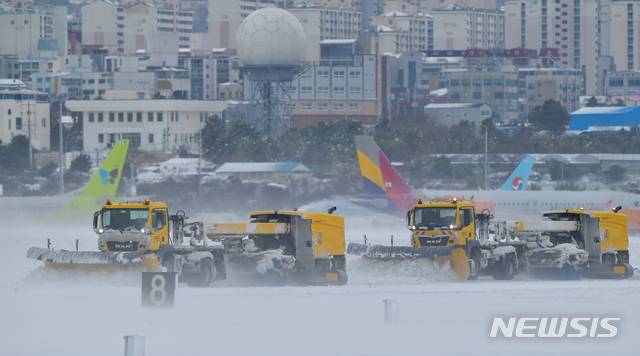 [제주=뉴시스]우장호 기자 = 북극발 한파가 사흘째 기승을 부리고 있는 8일 제주국제공항 활주로에서 제설차가 쌓인 눈을 치우고 있다. 2021.01.08. woo1223@newsis.com