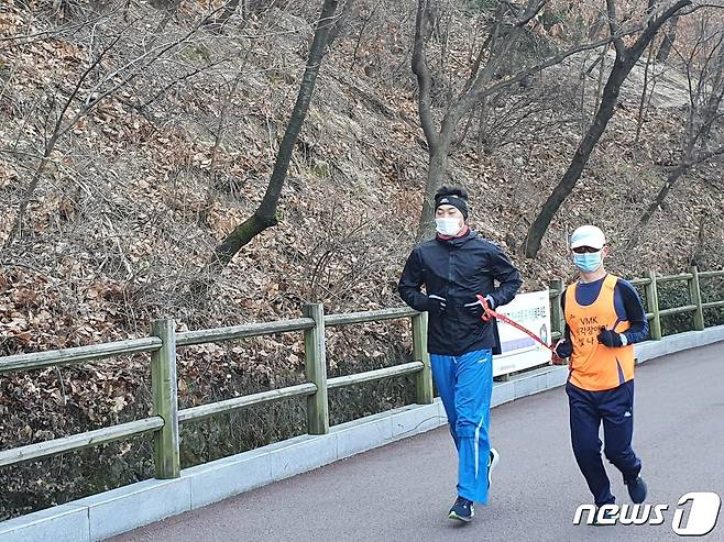 전맹(全盲) 장애인 마라토너 정운로씨(50)와 그를 돕는 동반주자 조성수씨(30)가 남산을 달리고 있다. © 뉴스1/정혜민 기자