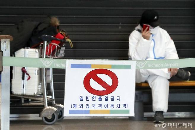 [인천공항=뉴시스]최진석 기자 = 공항으로 입국하는 모든 외국인들의 신종 코로나바이러스 감염증(코로나19) 유전자증폭(PCR) 검사 음성 확인서 제출 의무화를 하루 앞둔 7일 인천국제공항 제1터미널 입국장에서 방역복을 입은 외국인 입국자가 대기하고 있다. 2021.01.07. myjs@newsis.com