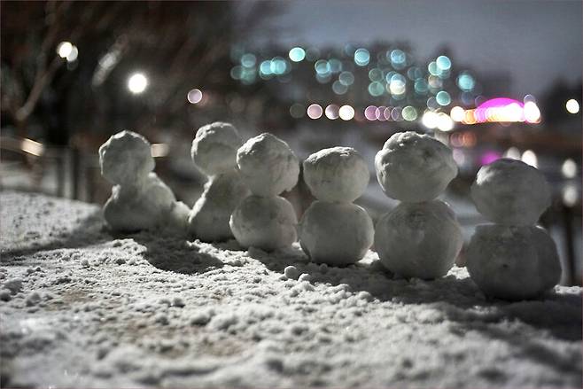 눈 내리는 밤. 가로등 아래서 나란히 서 있는 눈사람들의 모습이 유난히 정겹다. “지금 혼자가 되지 않으면 영영 혼자가 될 수도 있다”는 표어가 피부로 느껴지는 요즈음, 잃어버린 일상에 대한 간절함을 담아 빚어놓은 어울림의 풍경은 아닐는지. 모두가 하루빨리 스스럼없이 어우러지는 일상을 되찾기를 바라는 마음으로 새로운 한 해를 시작한다. 사진하는 사람