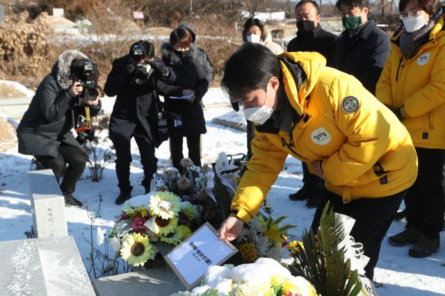 정의당 김종철 대표(가운데)가 10일 경기도 남양주시 모란공원 고(故) 노회찬 의원 묘소에서 중대재해 처벌 등에 관한 법률안(중대재해법)을 들고 있다. 국회는 지난 8일 본회의를 열어 중대재해법 제정안을 의결했으며, 앞서 이 법안은 고 노회찬 의원이 처음 발의한 바 있다. 연합뉴스