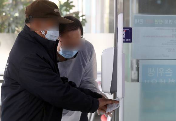 진주 경상대병원 입구에서 손 소독 중인 진주 시민. &copy;연합뉴스