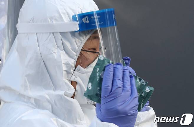 최강 한파가 기승을 부린 7일 오전 대전 서구보건소에 마련된 선별진료소에서 의료진이 핫팩으로 추위를 버티고 있다. 2021.1.7/뉴스1 © News1 김기태 기자