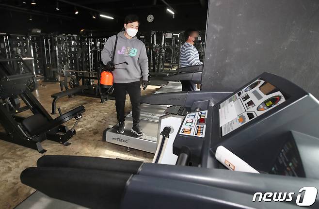 11일 오전 부산 부산진구의 한 헬스장에서 업주가 신종 코로나바이러스 감염증(코로나19)방역을 하고 있다. 이날 부산시는 헬스장 등 실내체육시설에 대해 오전5시부터 오후9시까지 영업을 허용하기로 했다. 2021.1.11 /뉴스1 © News1 여주연 기자