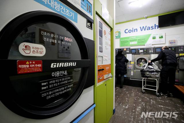 [서울=뉴시스]김병문 기자 = 한파로 가정 내  동파사고가 이어진 11일 오후 서울 종로구 한 아파트 단지 인근 셀프빨래방에서 한 주민이 세탁을 하고 있다. 2021.01.11. dadazon@newsis.com